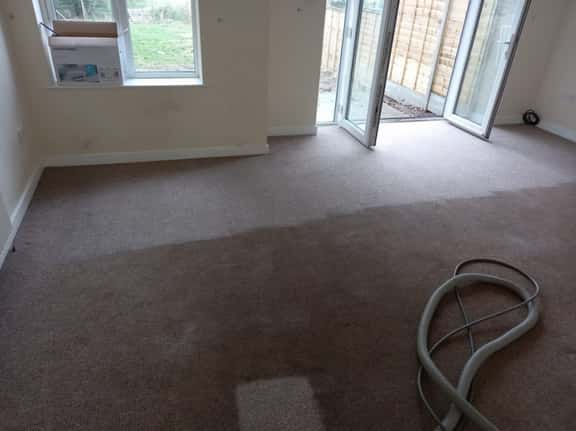 This is a photo of an empty living room with a brown carpet that is in the process of having its carpets steam cleaned Blackheath Carpet Cleaning