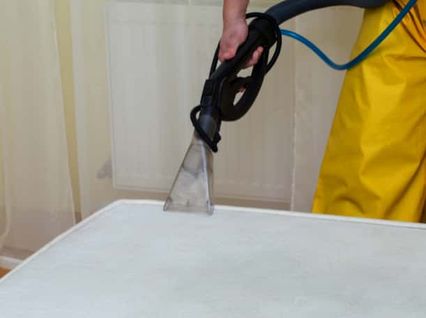This is a photo of a man steam cleaning a dirty mattress carried out by Blackheath Carpet Cleaning.