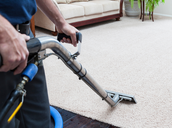 This is a photo of a man with a steam cleaner cleaning a cream carpet carried out by Blackheath Carpet Cleaning.